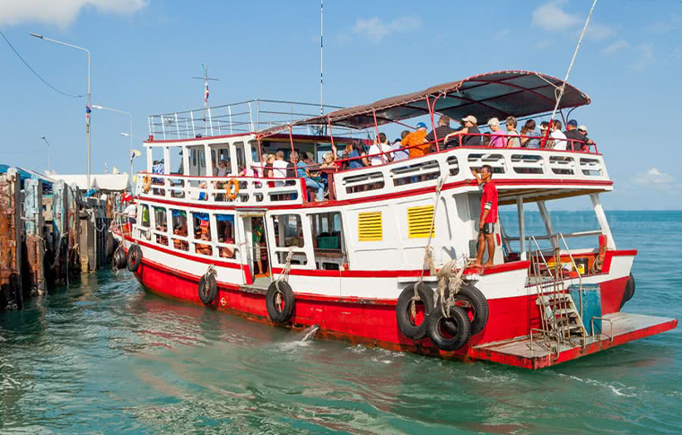 Large red and white boat floating at the pier welcoming passengers