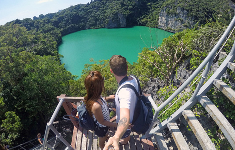 Couple taking a selfie overlooking an emerald green lake
